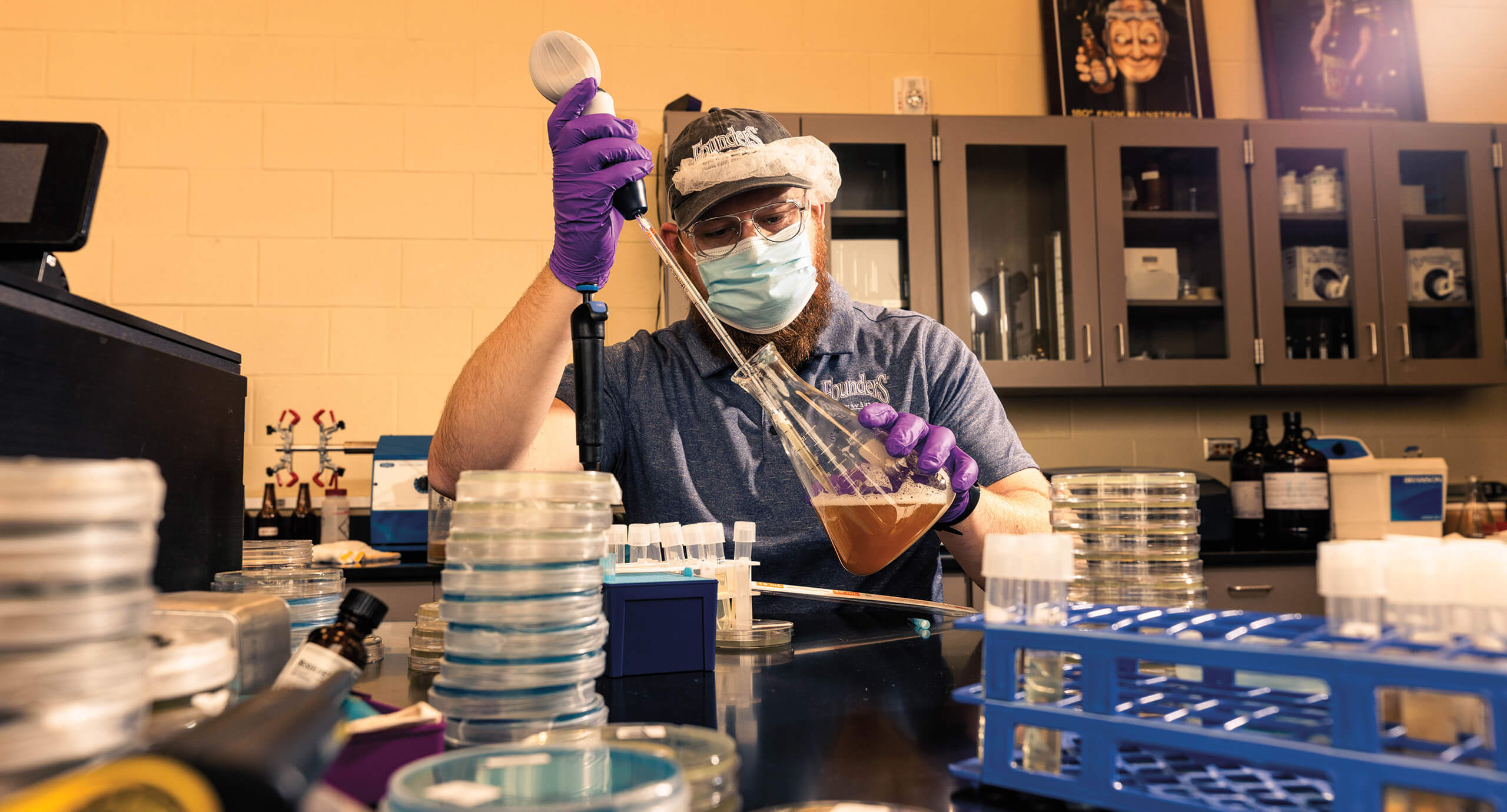 Founders employee mixing liquid in a chemistry flask